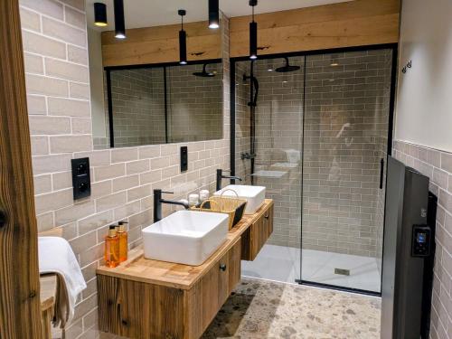 a bathroom with two sinks and a shower at Les Airelles by Lodji in Saint-Marcel