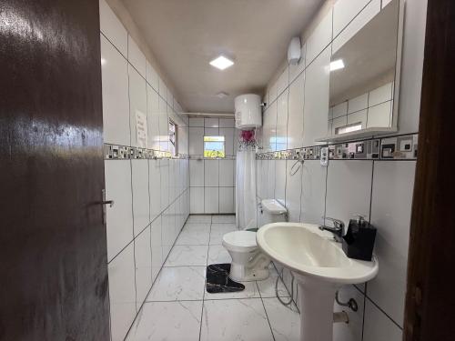a white bathroom with a sink and a toilet at Marvira Barra del Chuy in Xuí