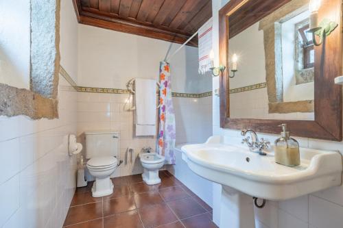 a bathroom with a sink and a toilet at Casas da Torre Medieval - by Proguest in Refoios do Lima