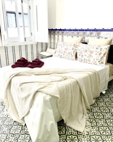 a bedroom with a large bed with white sheets and pillows at Zenit Olhao baixa one bedroom house sea side view in Olhão