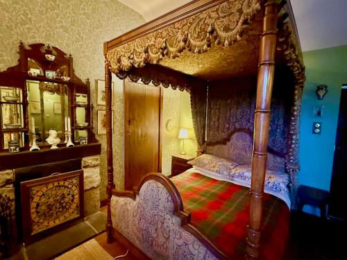 a bedroom with a canopy bed in a room at The Lady Maxwell Room at Buittle Castle in Dalbeattie