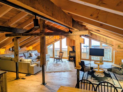 a large living room with wooden walls and ceilings at Les Framboisiers by Lodji in Saint-Marcel