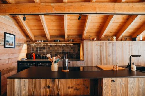 a kitchen with a black counter top in a cabin at Les Framboisiers by Lodji in Saint-Marcel
