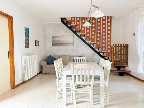 a white dining room with a white table and chairs at M274 - Marcelli, comodo quadrilocale vista mare con terrazzo in Marcelli