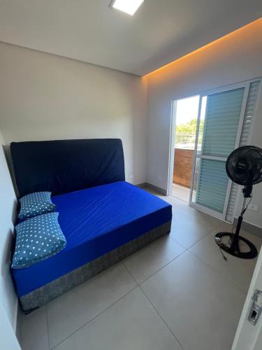 a blue bed in a room with a window at Espaço Viva Guarujá in Guarujá
