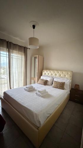 a large white bed in a bedroom with a window at Babis House in Pelekas