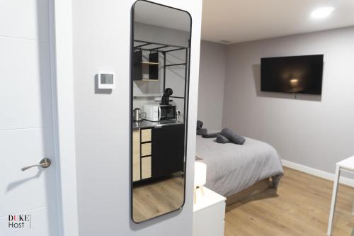a mirror in front of a bedroom with a bed at Sierra de Madrid Suites in Galapagar