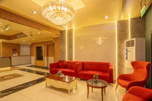 a living room with a red couch and a table at Regal Peninsula Hotel Formerly New Peninsula Hotel Ghubaiba Bus Station Bur Dubai in Dubai