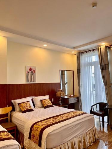 a hotel room with a large bed and a window at HOÀNG ĐẾ motel in Chau Doc