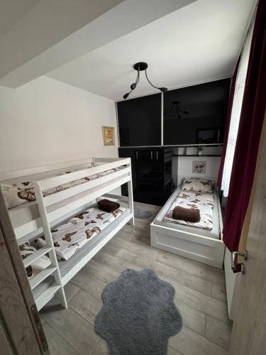 una camera da letto con due letti a castello e un tappeto di Apartman 