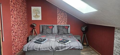 a bedroom with a bed in a red wall at Haut Doubs Plaisir SPA in Chamesol