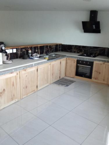 a kitchen with wooden cabinets and a stove top oven at Super boss in Saint-Benoît