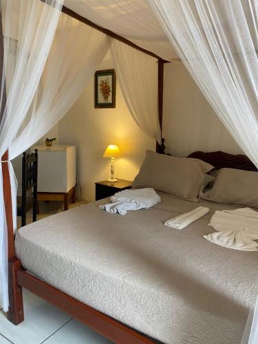a bedroom with a bed with a canopy at Pousada dos Candeeiros in Carolina