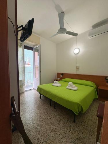 a green bed in a room with a window at Hotel San Paolo in Varazze