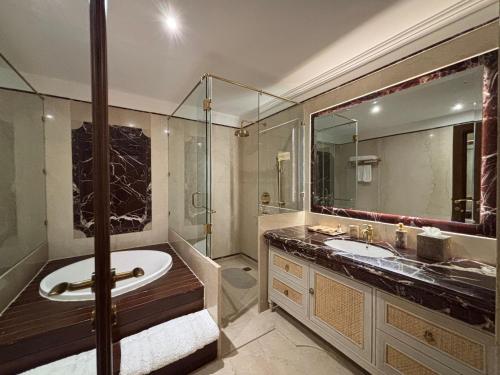 a bathroom with a tub and a sink and a shower at Fort Rajwada,Jaisalmer in Jaisalmer