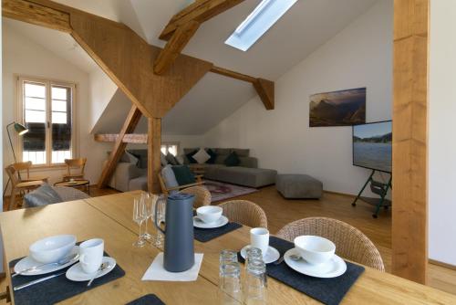 a dining room table with chairs and a living room at Adlerhorst -410- in Mittenwald