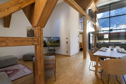 a dining room and living room with wooden beams at Adlerhorst -410- in Mittenwald