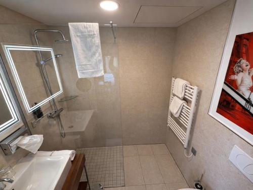 a bathroom with a shower and a sink and a shower at DORMERO DeHo Linz in Linz
