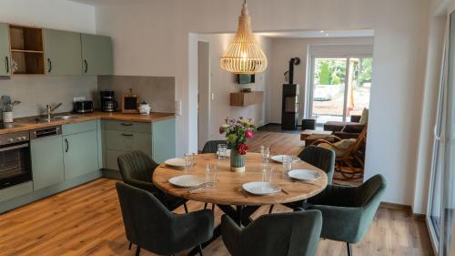 a kitchen and dining room with a table and chairs at Pension Spreewald Lächeln - Apartment Kahnfahrt durch den Spreewald in Treppendorf