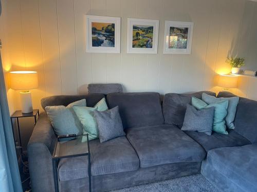 a living room with a couch with pillows on it at The Eden, Cosy 1 bed lodge with riverside views in Crieff