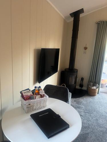 a white table with a book on top of it at The Eden, Cosy 1 bed lodge with riverside views in Crieff