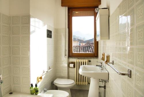 a bathroom with a sink and a toilet and a window at Cuor di Barzio P1 in Barzio