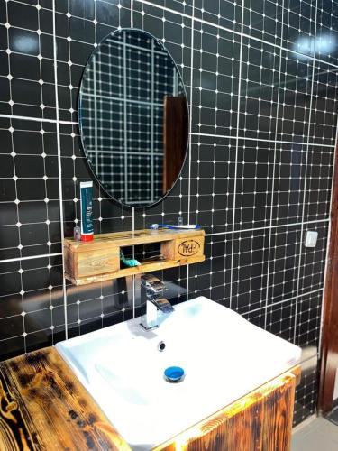a bathroom with a white sink and a mirror at Maison meublée Odza Yaoundé in Yaoundé