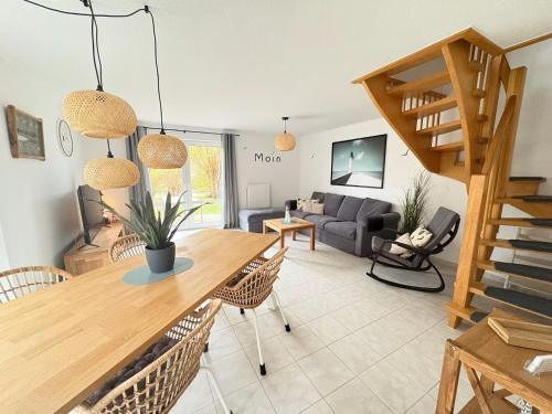 a living room with a wooden table and chairs at Sielkate in Dornum