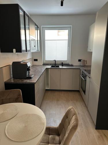 a kitchen with a table and a counter top at Brzostek Apartamenty in Marki