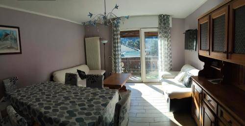 a bedroom with a bed and a couch and a window at Azalea in Canazei