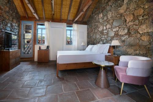 a bedroom with a bed and a couch and a chair at Lyhnos in Askas