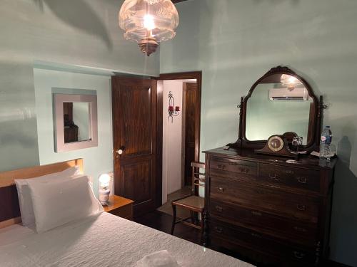 a bedroom with a bed and a dresser with a mirror at Quinta do Rossio, Rural Tourism in Biscoitos