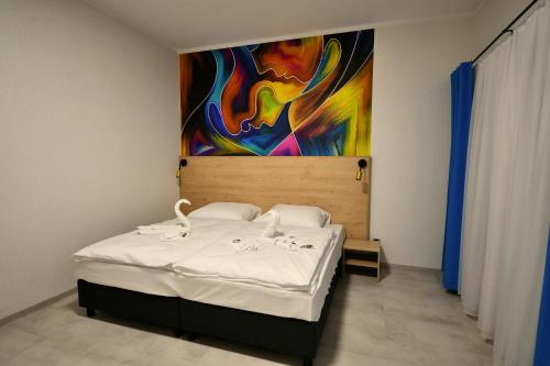 a bedroom with a bed with a painting on the wall at Za Bunkrem 2 0 in Zbrosławice