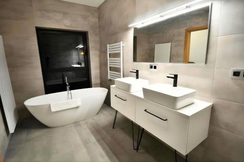 a bathroom with two sinks and a large mirror at Za Bunkrem 2 0 in Zbrosławice