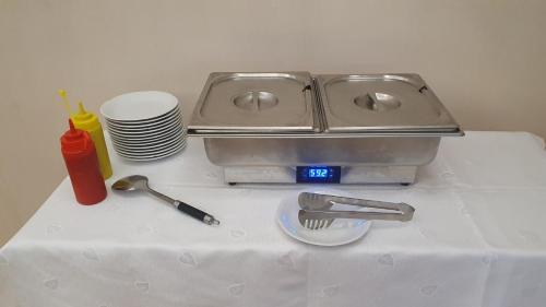 a kitchen counter with a sink and plates and utensils at Leśny Dwór - śniadanie i parking w cenie in Szczecinek