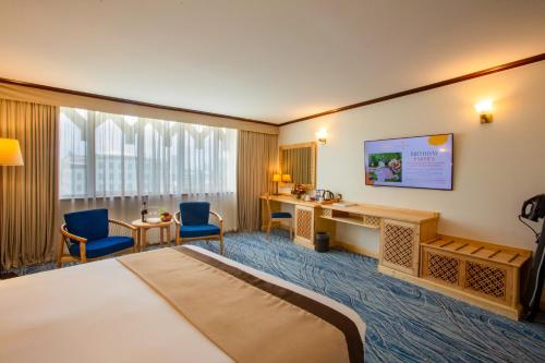 a hotel room with a bed and a desk and chairs at Dar es Salaam Serena Hotel in Dar es Salaam