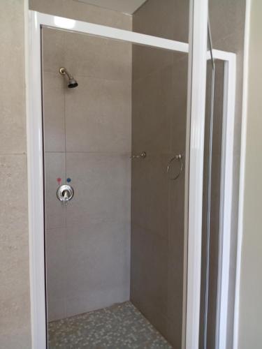 a shower with a glass door in a bathroom at Hlalanathi Lodge - 9 Shepstone Road, Harding in Harding