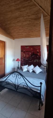 una camera da letto con un letto grande con soffitto in legno di Villa Nianing a Nianing