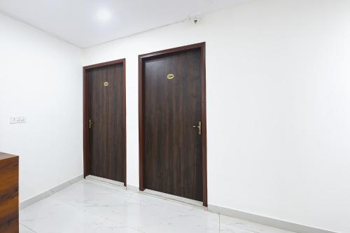 two wooden doors in a room with white walls at FabHotel Resto Relax in New Delhi