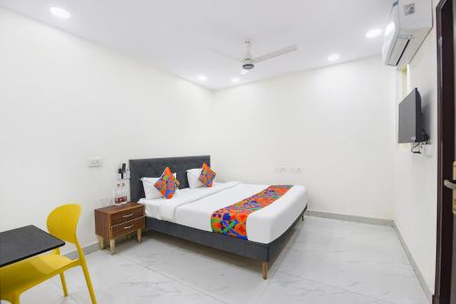 a bedroom with a bed and a table and a chair at FabHotel Resto Relax in New Delhi