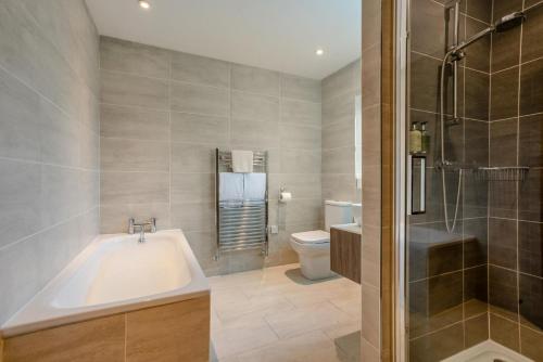 a bathroom with a tub and a toilet and a shower at 4 Bed in Catterick oc-y33625 in Catterick Bridge