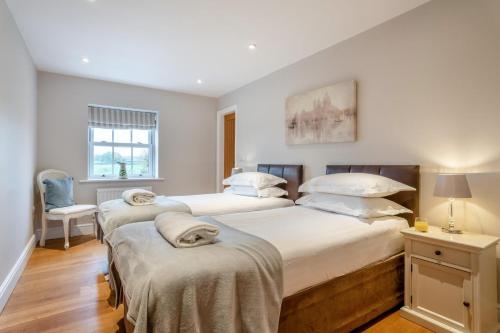 a bedroom with two beds and a chair at 4 Bed in Catterick oc-y33625 in Catterick Bridge
