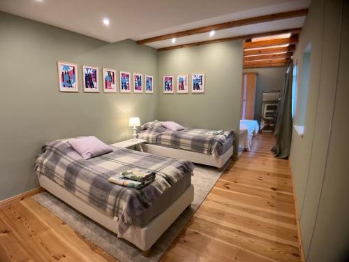 two beds are in a room with wooden floors at Cottage in Kleinmachnow