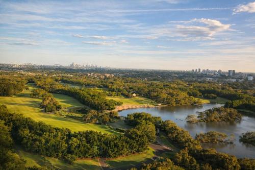 an aerial view of a golf course next to a river at Stylish Olympic Park Stay - Park View and Dining in Sydney