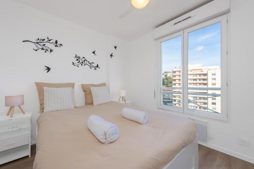 a white bedroom with a large bed and a window at Haut de Monaco - Vue panoramique mer et ville - FE in Beausoleil