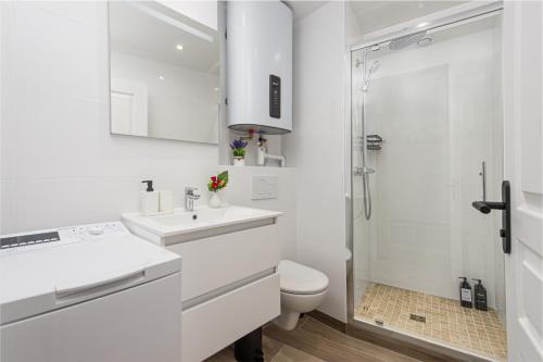 a white bathroom with a toilet and a shower at Haut de Monaco - Vue panoramique mer et ville - FE in Beausoleil