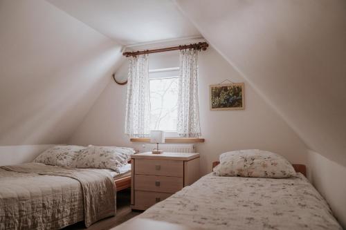 a attic bedroom with two beds and a window at Bogdanówka in Supraśl