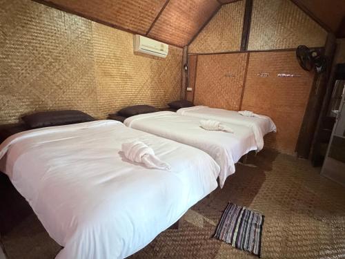 three beds in a room with white sheets at Hometown Pai Boutique Bungalow in Pai