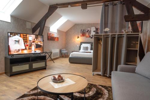a living room with a bed and a tv and a couch at Ô Spa Champenois in Écueil