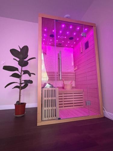 a room with a pink lighted room with a plant at Cocon Diamant - Nuit Romantique - Jacuzzi et Sauna - Hyper-Centre in Compiègne
